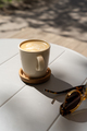 Cup with cappuccino and sunglasses on cafe terrace. Travel, vacation concept. - PhotoDune Item for Sale