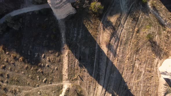 Top Drone View of the Field and Cone Shaped Volcanic Formation with Walking Tourists on Horses