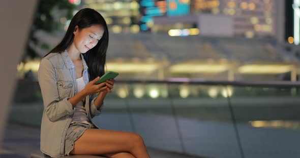 Young woman looking at mobile phone at night