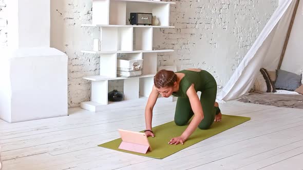 Slender Woman Practices Yoga Online Using a Digital Tablet