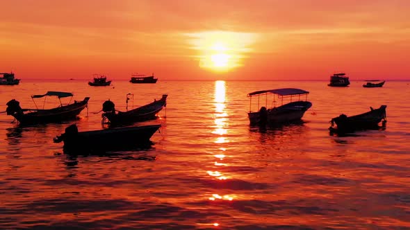 Aerial shot of Koh Tao island, Super sunset at Sairee Beach with many boats floating Thailand