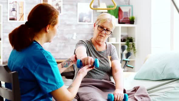 Nurse in Retirement Home Helping an Elderly Woman To Recover Her Muscle Strength