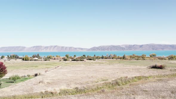 Large Blue Utah Lake with Fields, Trees, and Mountain Range Aerial Drone 4K