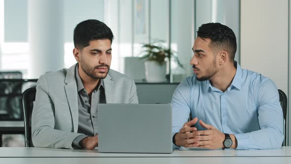 Two Male Colleagues Employees Cooperating in Office Talking Working Together at Workplace Serious