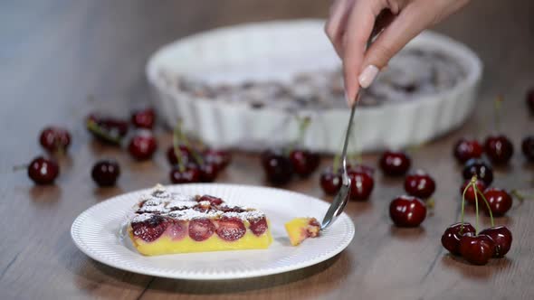 Eating a piece of clafoutis with cherries