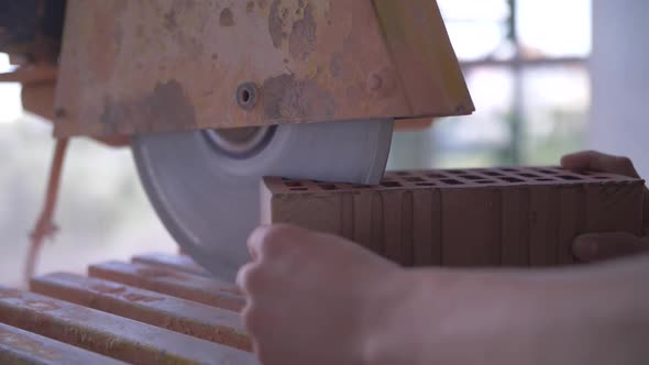 sawing red brick with a circular saw