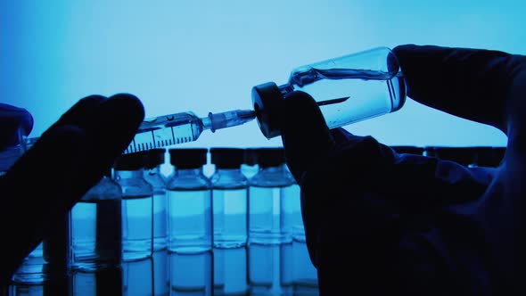 Vaccine bottles and syringe injection. Glass vials for liquid samples in laboratory.