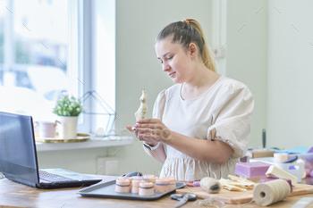nding at her shop behind the laptop and smiling. female online store seller entrepreneur packing package post shipping box preparing delivery parcel