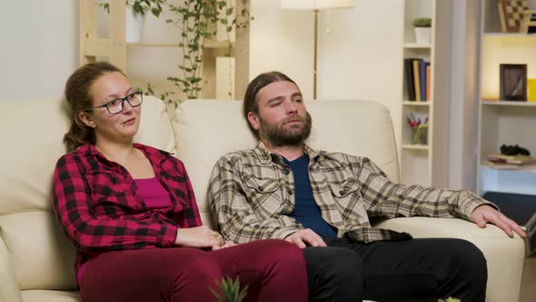 Couple Relaxing on Sofa and Talking with Each Other