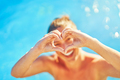 Picture of woman in swimming pool showing heart with her hands - PhotoDune Item for Sale