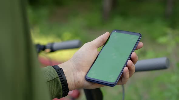 Closeup of Mans Hand Tap on Chromakey Screen of Smartphone for Renting an Electric Scooter