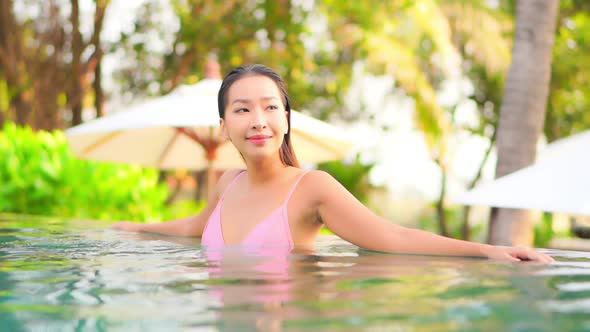 Young asian woman enjoy around outdoor swimming pool for leisure