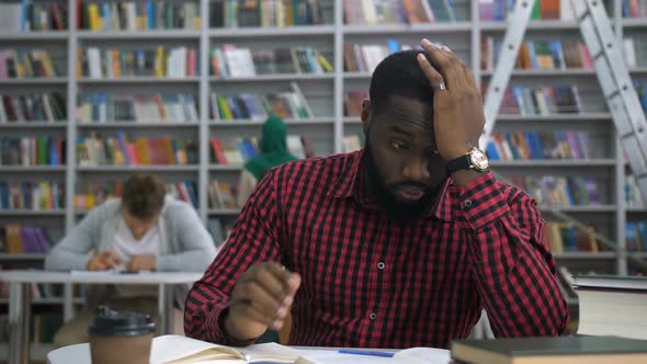 Exhausted Dark-skinned Student Massaging Temples