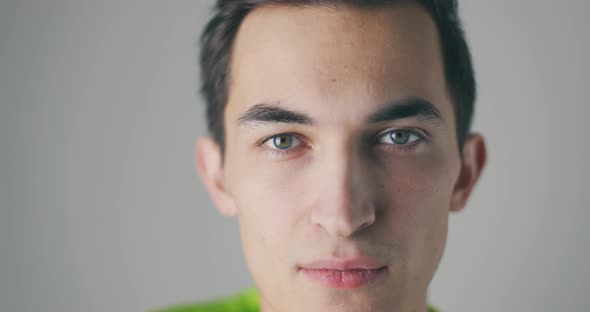 Close Up Portrait of Serious Handsome Caucasian Man Over Grey Studio Background Looking at Camera in