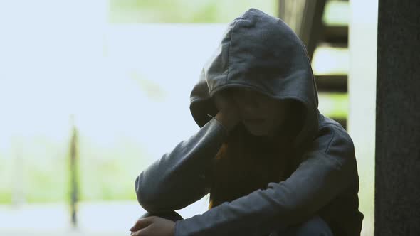 Melancholic Teen Female in Hoodie Touching Face With Palm, Suffering Depression