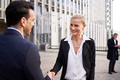 A businesswoman shaking hands with her colleague outside the office building - PhotoDune Item for Sale