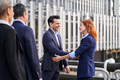 Business woman shaking hands with her colleague while talking and laughing - PhotoDune Item for Sale