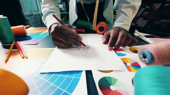 African Designer is Drawing a Dress on Paper