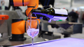 Futuristic automated robotic arm pours liquid into a glass. - PhotoDune Item for Sale