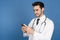 Smiling young doctor using mobile phone. - PhotoDune Item for Sale