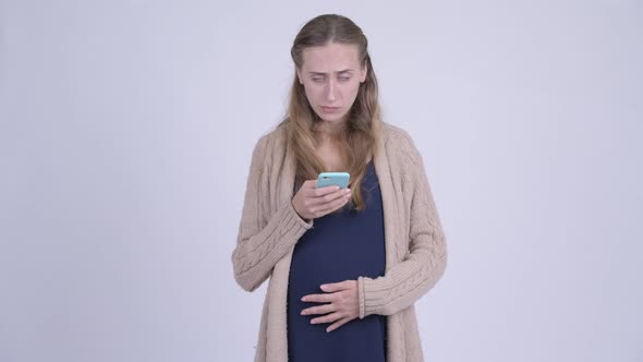 Stressed Young Pregnant Woman Using Phone and Getting Bad News