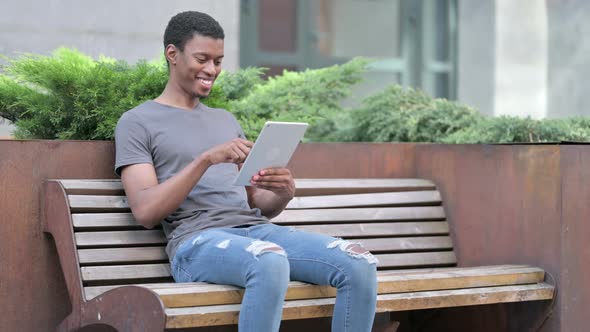 Professional Young Young African Man Using Tablet on Bench 