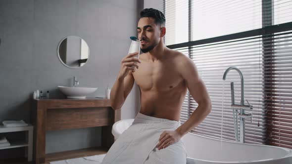 Arab Indian Guy Muscular Naked Sexy Unshaven Man Wears White Bath Towel on Hips Sits in Bathroom