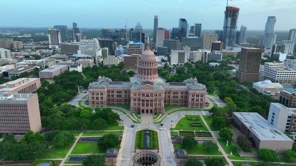 Dramatic aerial flight over dome and statue reveals downtown urban Austin Texas cityscape. TX Capito