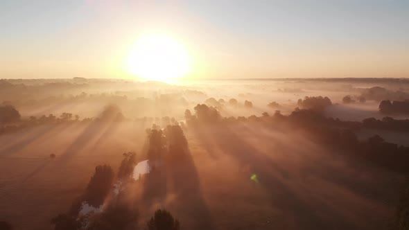 Aerial footage with cameraing sideways across the east anglian countryside with low lying mist just