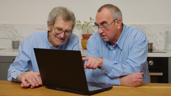 Senior Mature Older Mans Using a Laptop While Relaxing at Home