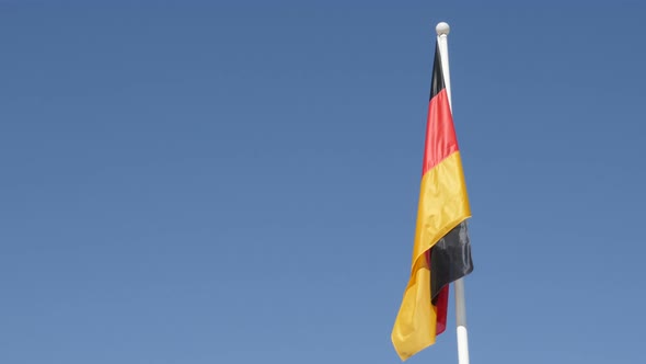 National flag of Germany waving against blue sky 4K 2160p 30fps UltraHD footage - German  state symb