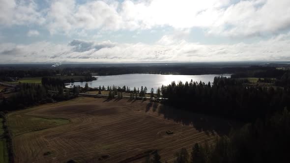 Drone shot flying over a lake and farmland in Oulanka National Park, Finland