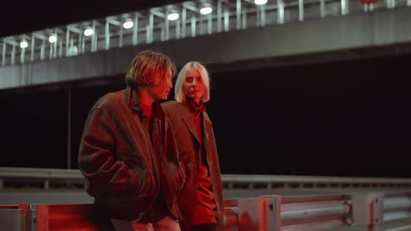 Young Couple Standing on Road at Night and Speaking