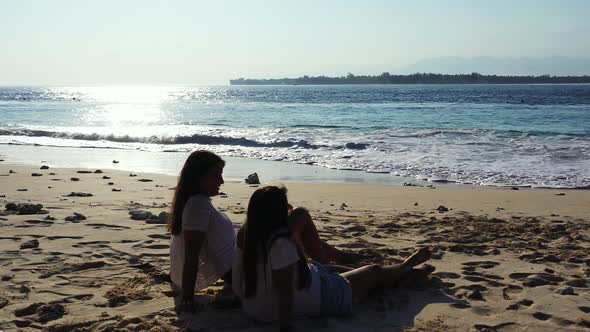 Sexy smiling ladies travelling spending quality time on beach on summer white sandy and blue 4K back