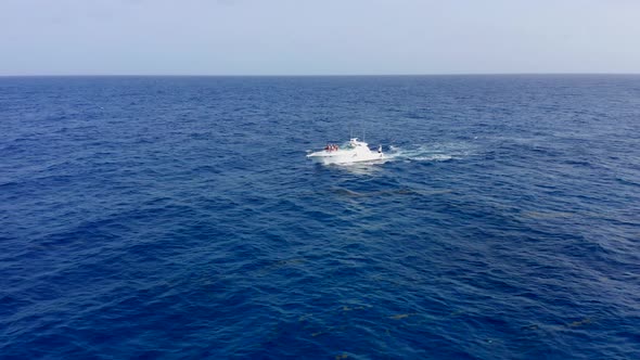 Incredible aerial shot in the open sea with a view of a white boat sailing in cap cana, Dominican Re