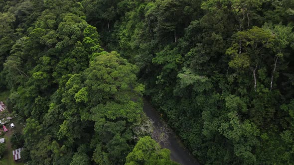 Drone approaching road leading through the thick rainforests of Costa Rica near La Fortuna. Wet natu