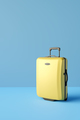 Yellow suitcase on blue background. 3D rendering - PhotoDune Item for Sale