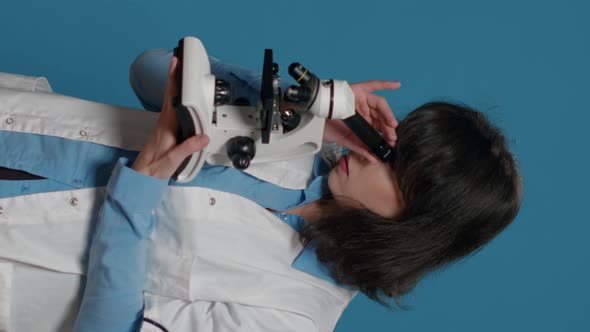 Vertical Video Chemistry Researcher Using Microscope with Magnifying Glass