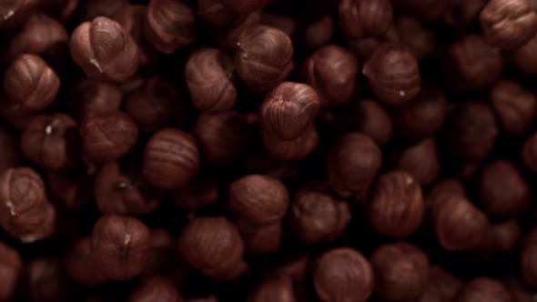 Super Slow Motion Shot of Hazelnuts Flies After Being Exploded Against Black Background 1000Fps