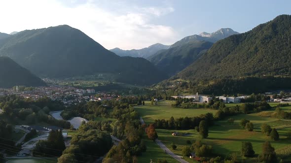 Aerial drone shot of the town of Tolmin in Slovenia with a mountain range backdrop.