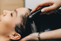 The hairdresser washes the head of a girl in a barbershop. brunette came for a haircut - PhotoDune Item for Sale