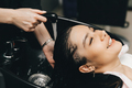 The hairdresser washes the head of a girl in a barbershop. brunette came for a haircut - PhotoDune Item for Sale