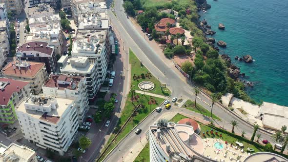 aerial drone circling a coastal road in Antalya Turkey on a sunny summer day as cars drive off from