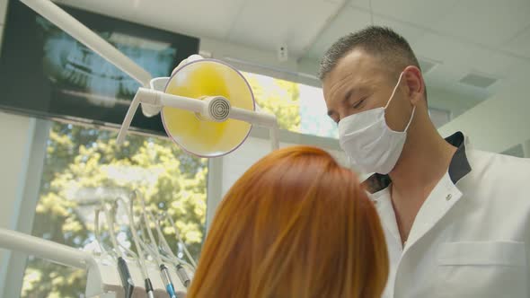 Orthodontist Covering Special Gel on Woman Teeth and Drying It in Dentistry Before Braces Installing