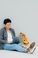 Woman sitting with her back to wall works with computer Urban lifestyle portrait - PhotoDune Item for Sale