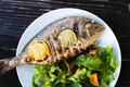 Grilled dorada fish with lemon pieces on white plate - PhotoDune Item for Sale