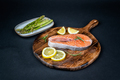 Fresh raw salmon slice with lemon and rosemary on a wooden board - PhotoDune Item for Sale