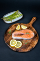 Fresh raw salmon slice with lemon and rosemary on a wooden board - PhotoDune Item for Sale