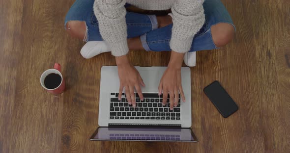 Woman using laptop and drinking coffee