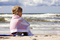 Little girl sitting on the beach and looking - PhotoDune Item for Sale